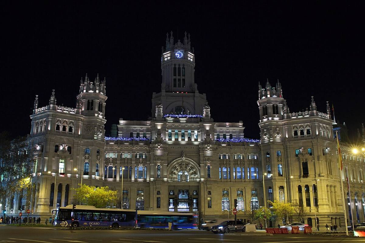Fachada principal del Palacio de Cibeles, sede del Ayuntamiento de Madrid, iluminada de noche.
