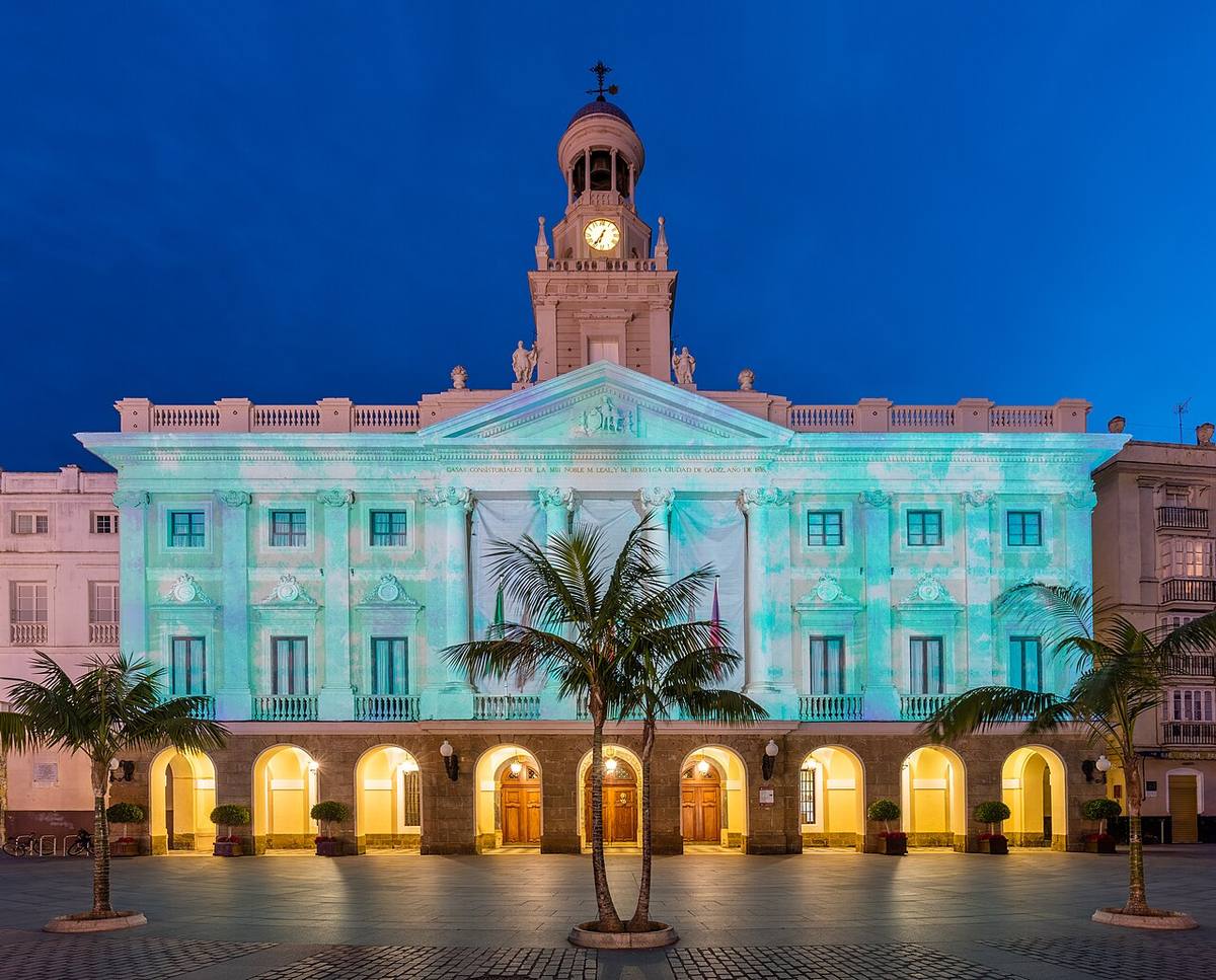 Fachada del Ayuntamiento de Cádiz iluminada al anochecer.