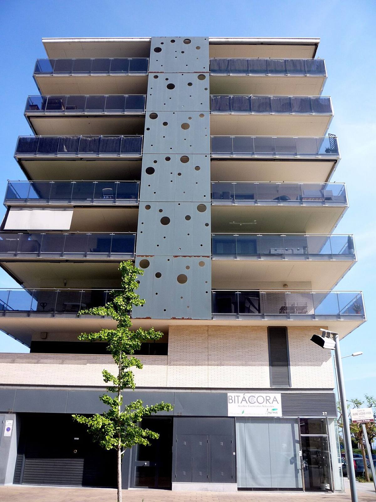 Edificio de apartamentos de arquitectura moderna con balcones acristalados.