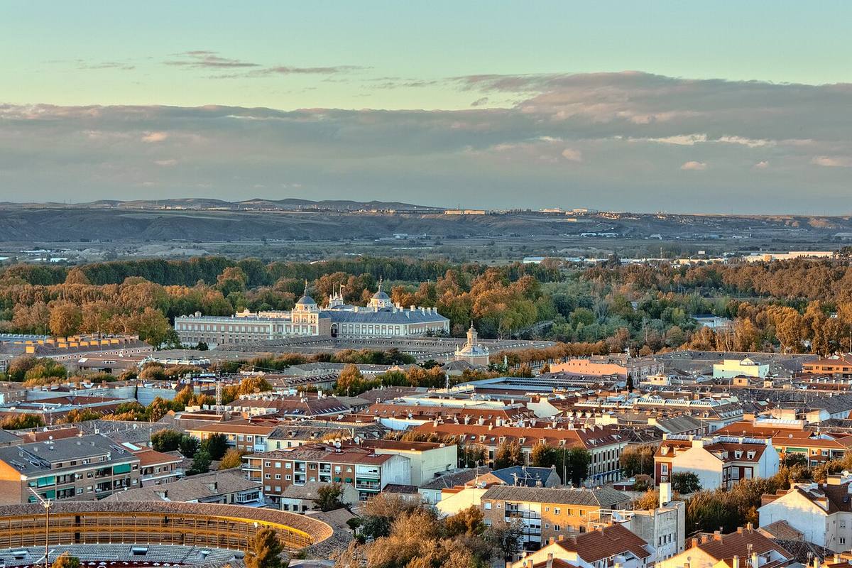 Vista aérea de una zona residencial en la Comunidad de Madrid con el Palacio Real de Aranjuez al fondo.