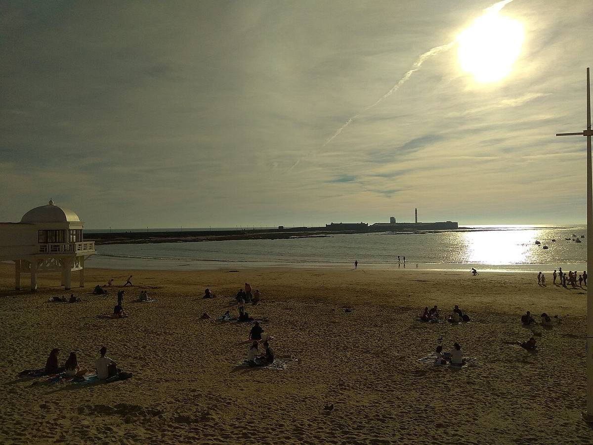 Bañistas al atardecer en la playa de la Caleta, Cádiz.
