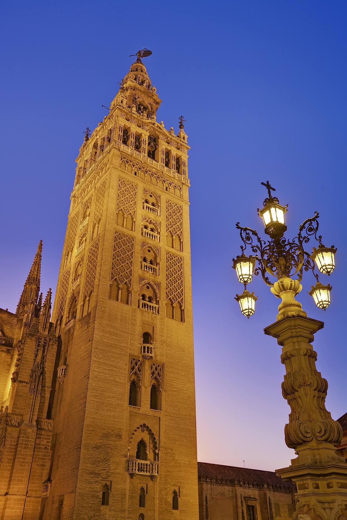 La torre de la Giralda iluminada al atardecer en Sevilla.