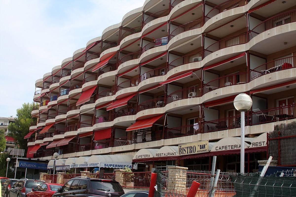Fachada de un edificio de apartamentos turísticos y locales comerciales.