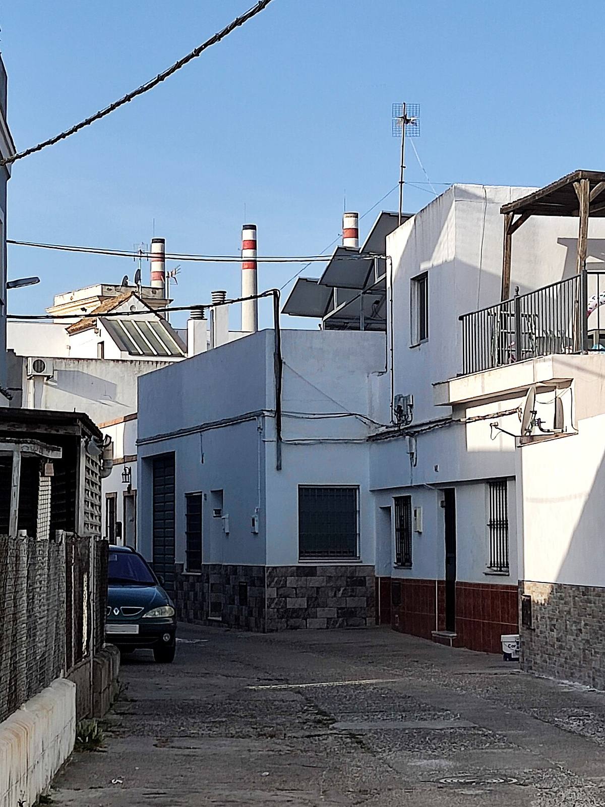 Casas de El Pelirón con las chimeneas de la fábrica de botellas al fondo.