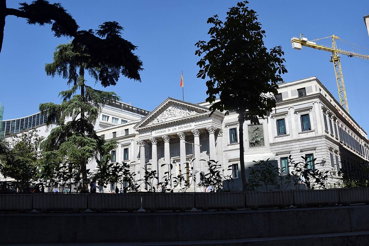 Perspectiva del Congreso de los Diputados con una grúa de construcción al fondo.