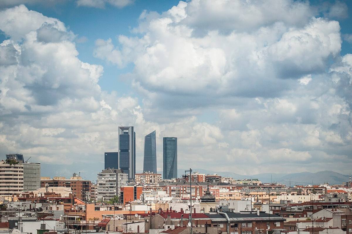 Skyline de Madrid con edificios residenciales en primer plano y las Cuatro Torres al fondo.