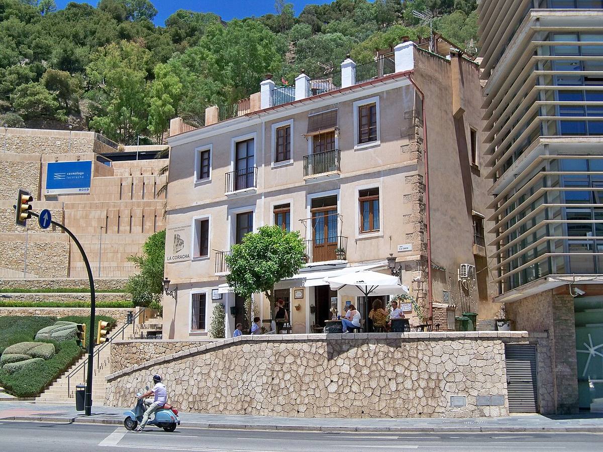 Edificio histórico con terraza turística en la ciudad de Málaga.