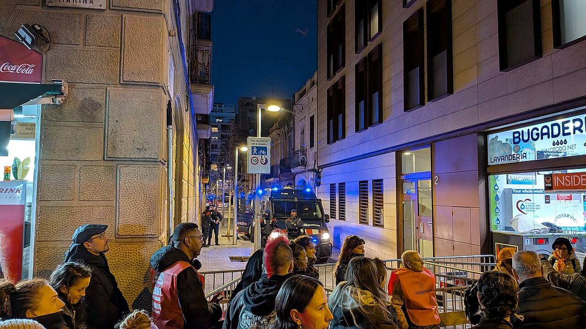 Concentración ciudadana en una calle de Barcelona ante la sede de un partido político.