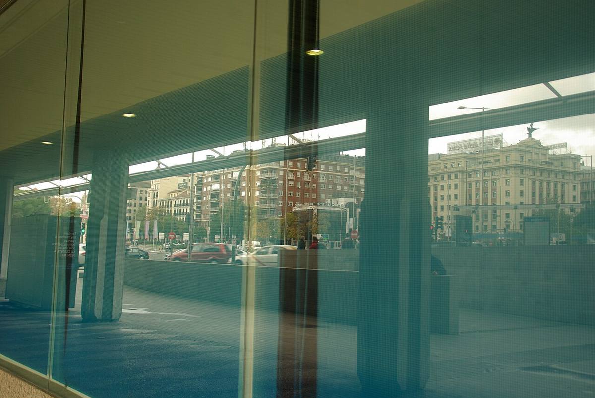 Reflejos de edificios residenciales en una cristalera de Madrid.