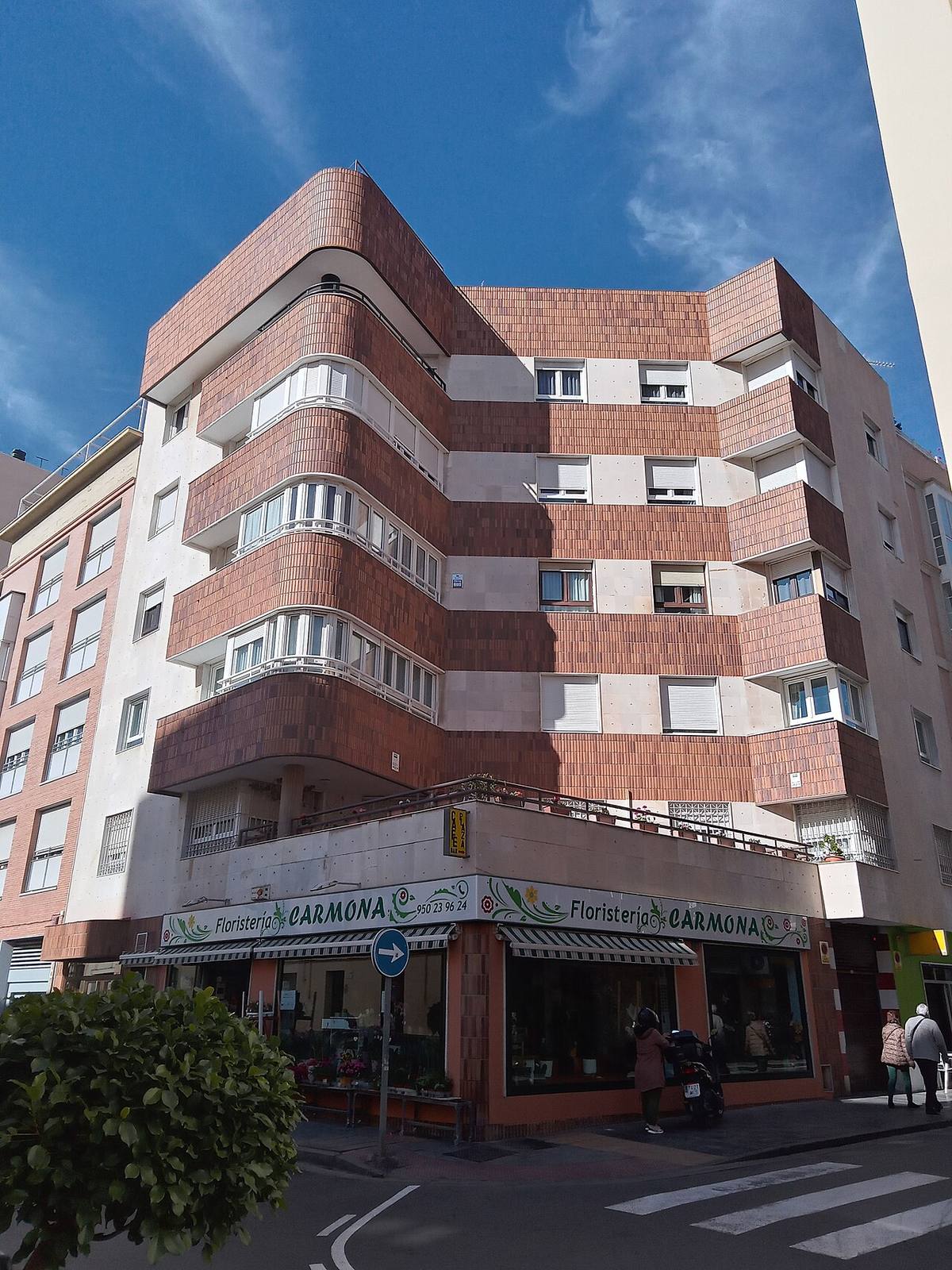 Edificio de uso mixto con viviendas en plantas superiores y locales comerciales en la planta baja.