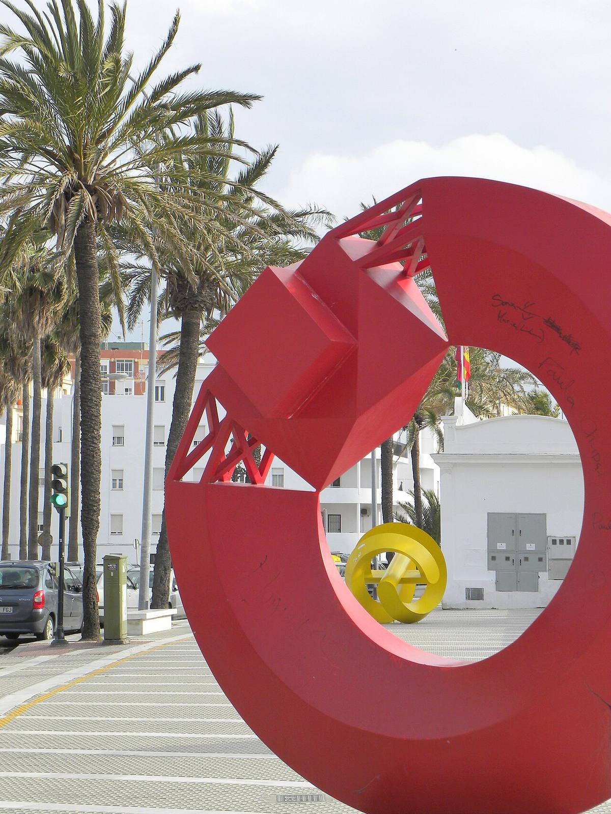 Esculturas modernas y edificios residenciales junto a la playa de la Caleta en Cádiz.
