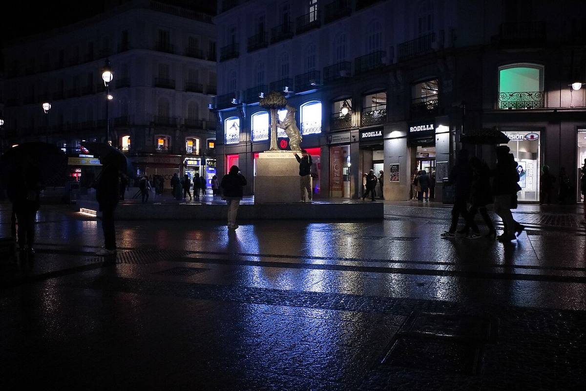 Vista nocturna de la Puerta del Sol con la estatua del Oso y el Madroño al fondo.