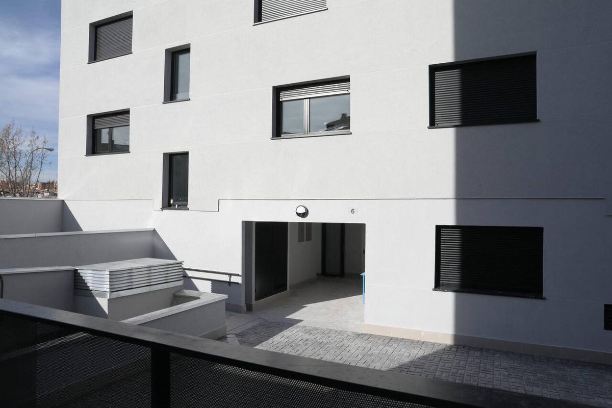 Detalle de la fachada y acceso a un edificio de viviendas de la EMVS en Madrid.